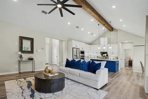 a living room with furniture and a wooden floor