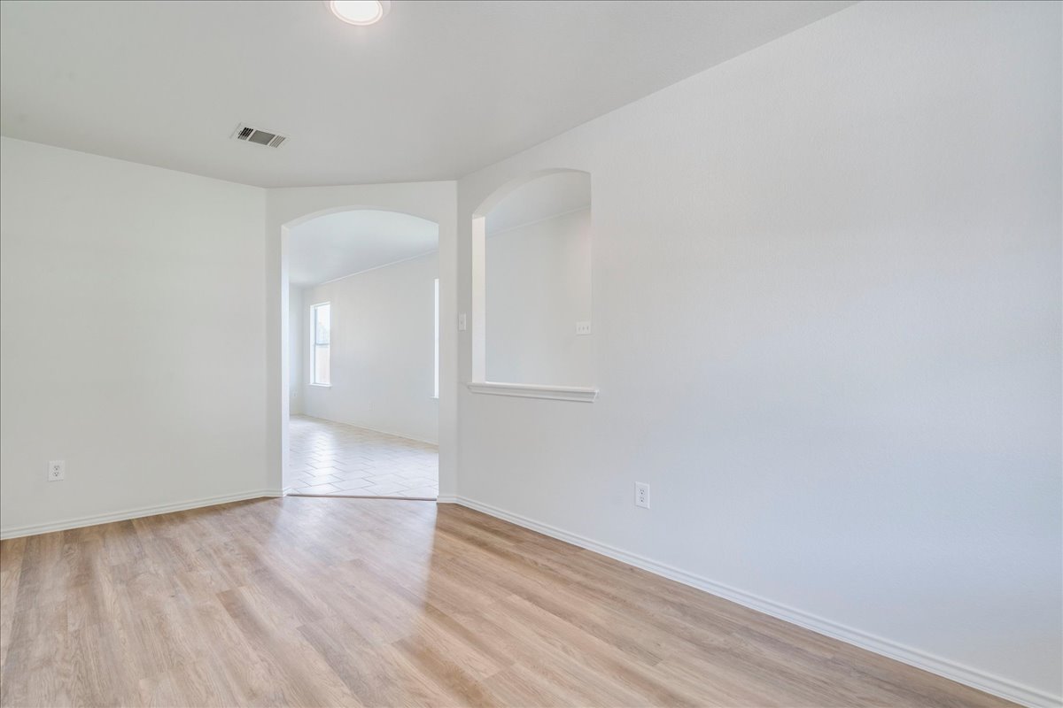 100 Easy Street Hutto, TX 78634 - Photo 24 of 36 Archways and a pass-through window connect the open-concept living spaces, highlighted by durable flooring.