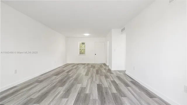 a view of empty room with wooden floor