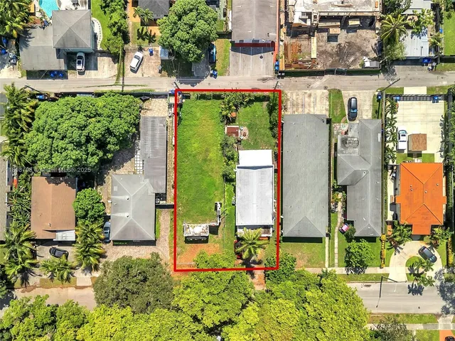 front view of a house with a yard and potted plants