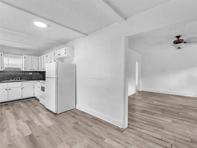 a view of a kitchen with wooden floor and electronic appliances