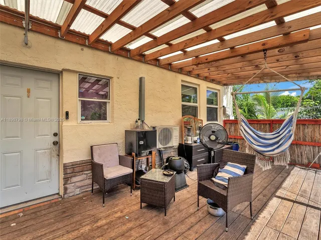 a backyard of a house with barbeque oven table and chairs