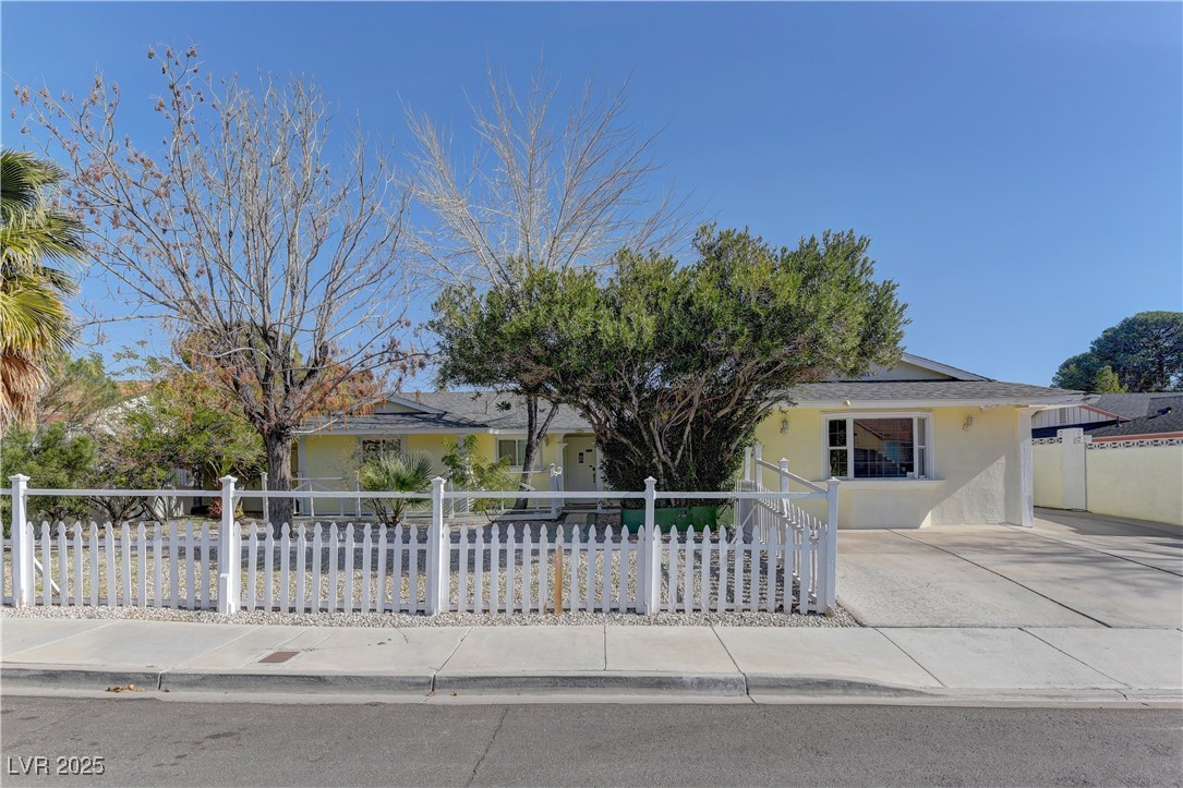 Single story home featuring a fenced front yard and stucco siding