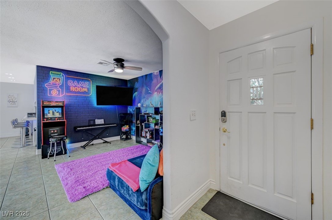 5248 Rambling Road Las Vegas, NV 89120 - Photo 15 of 33 Tiled entryway featuring ceiling fan, arched walkways, and a textured ceiling