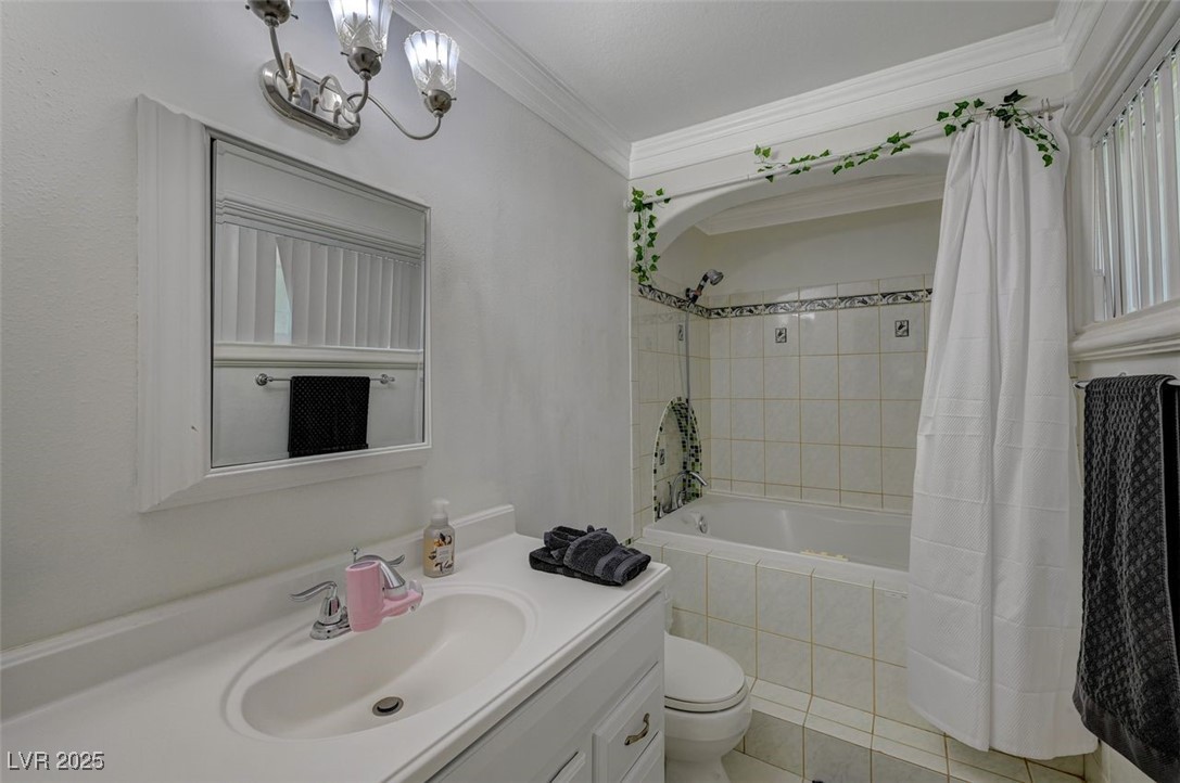 5248 Rambling Road Las Vegas, NV 89120 - Photo 18 of 35 Full bath with vanity, ornamental molding, tiled shower / bath, light tile patterned floors, and a chandelier