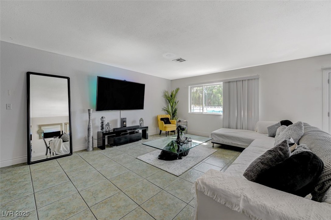 5248 Rambling Road Las Vegas, NV 89120 - Photo 21 of 35 Tiled living area featuring baseboards and a textured ceiling