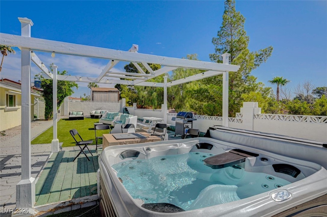 5248 Rambling Road Las Vegas, NV 89120 - Photo 27 of 33 Fenced backyard featuring a hot tub, grilling area, a patio, an outdoor hangout area, and a pergola