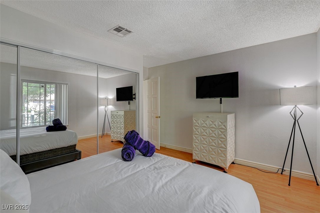 5248 Rambling Road Las Vegas, NV 89120 - Photo 28 of 33 Bedroom with light wood-style flooring, a textured ceiling, and a closet