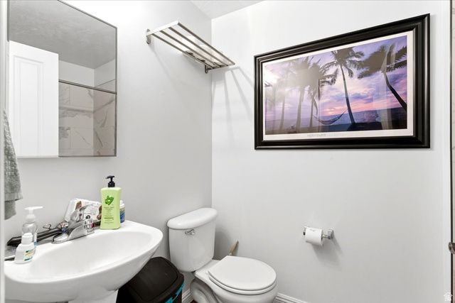 161 25th Street, Unit 6B Ogden, UT 84401 - Photo 15 of 20 Bathroom featuring a pedestal sink, wall-mounted mirror, and a toilet