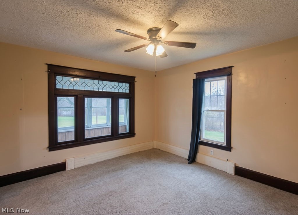 1195 South Johnson Road Sebring, OH 44672 - Photo 9 of 34 Empty room with light colored carpet, a textured ceiling, and a ceiling fan