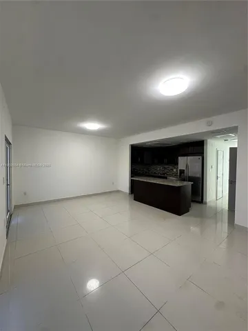 a living room with a stove and a refrigerator