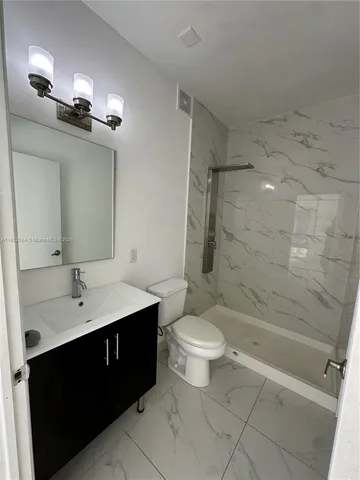 a bathroom with a double vanity sink toilet and shower