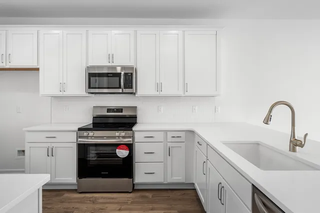 a kitchen with cabinets appliances a sink and a counter top