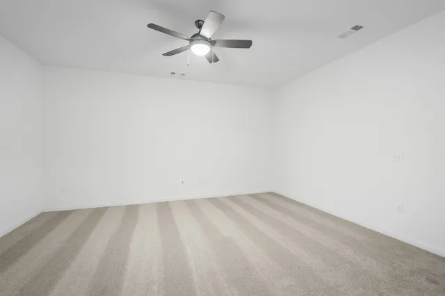 a view of an empty room with a ceiling fan