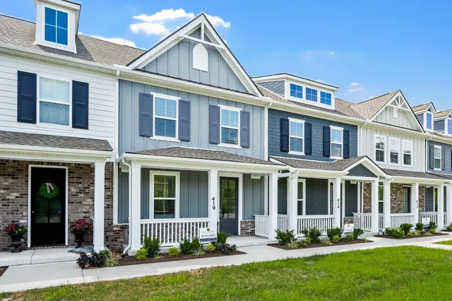 front view of a brick house with a yard