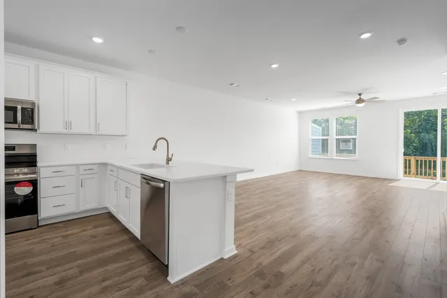 a kitchen with wooden floors and white cabinets