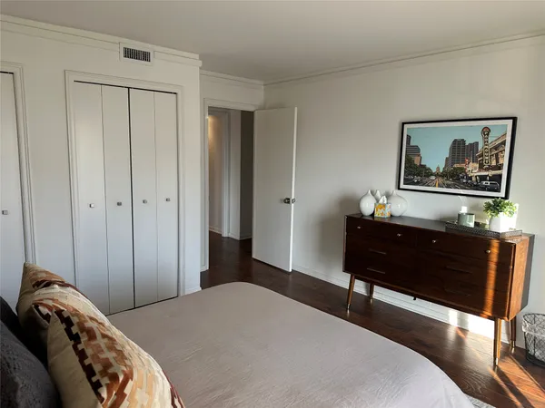 a bedroom with a bed and a painting on the wall