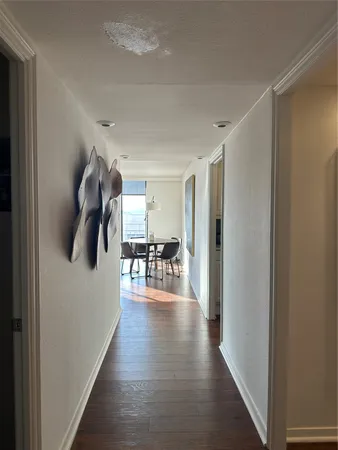 a hallway with hardwood floor and furniture