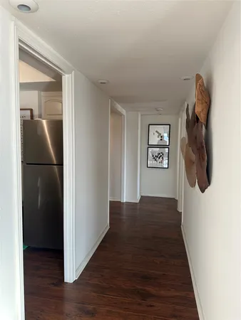 a view of a hallway with wooden floor and closet