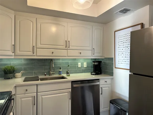 a kitchen with stainless steel appliances granite countertop a refrigerator sink and cabinets