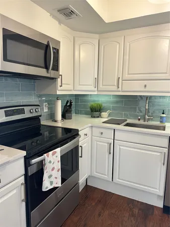 a kitchen with stainless steel appliances granite countertop white cabinets a sink and dishwasher
