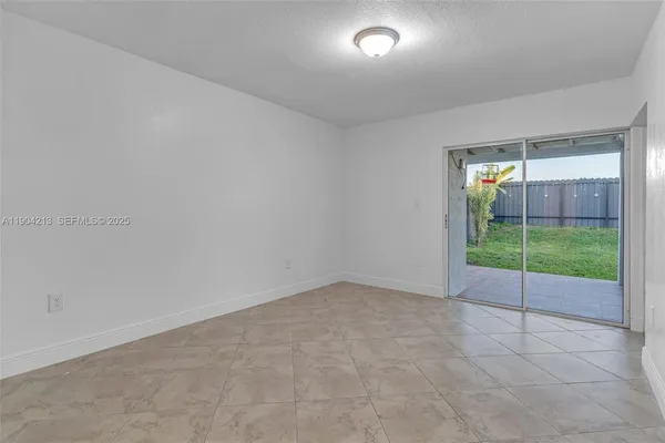 an empty room with floor to ceiling window and an outdoor view