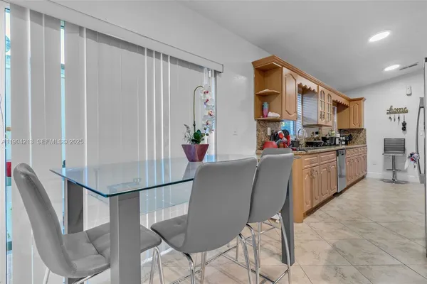 a living room with stainless steel appliances kitchen island granite countertop furniture and a refrigerator