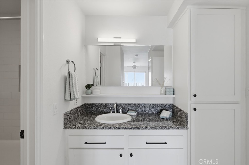 565 Esplanade, Unit 312 Redondo Beach, CA 90277 - Photo 21 of 32 a bathroom with a granite countertop sink and a mirror