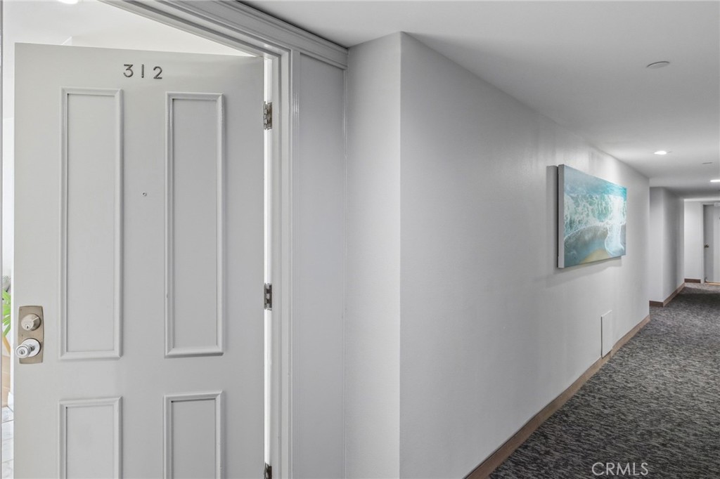565 Esplanade, Unit 312 Redondo Beach, CA 90277 - Photo 6 of 32 a view of a hallway with wooden floor and a bathroom