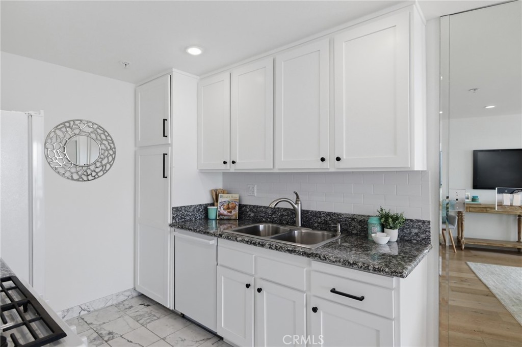 565 Esplanade, Unit 312 Redondo Beach, CA 90277 - Photo 9 of 32 a kitchen with granite countertop a sink a stove and cabinets