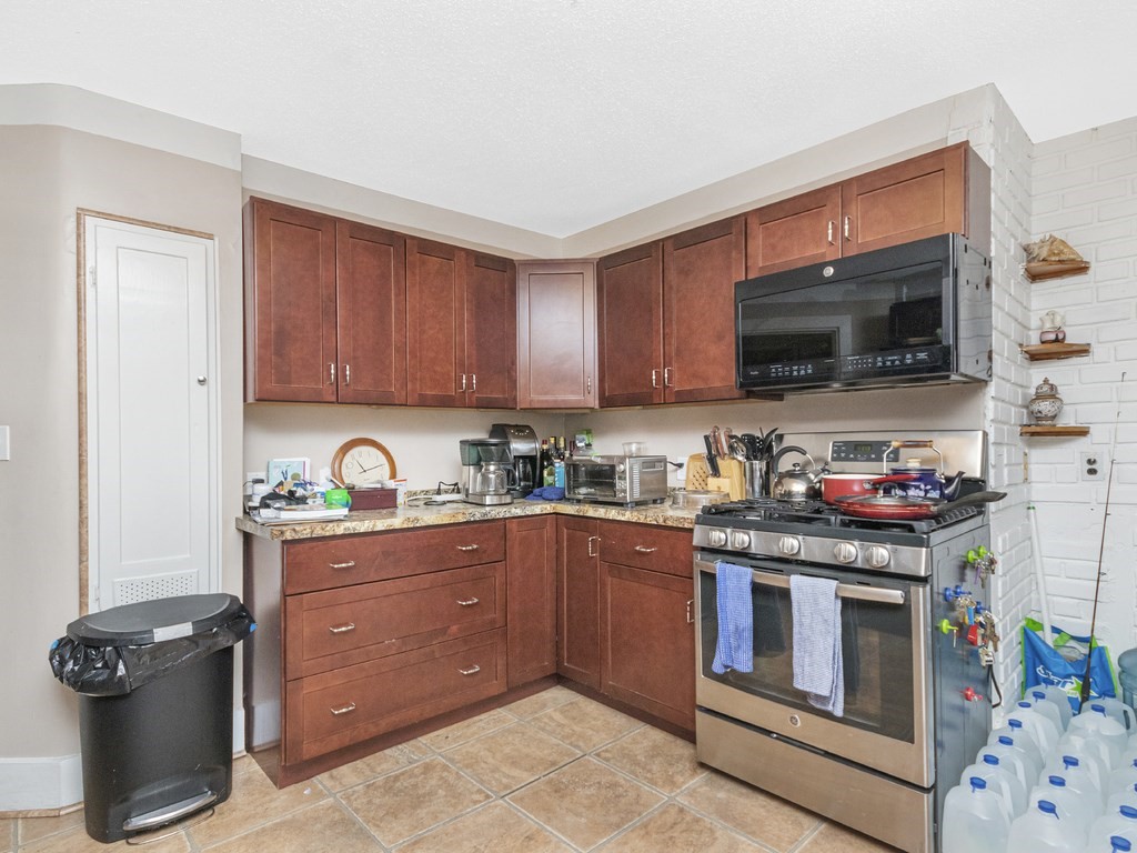 90 Addington Road, Unit 1 Brookline, MA 02445 - Photo 9 of 41 a kitchen with stainless steel appliances granite countertop a stove and a microwave