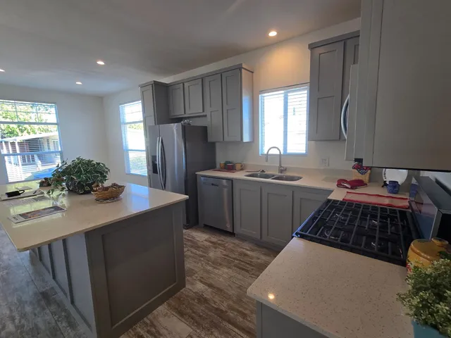 a kitchen with a sink a stove a refrigerator and cabinets