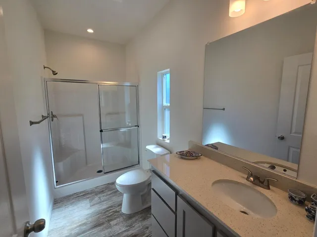 a bathroom with a sink a toilet and shower