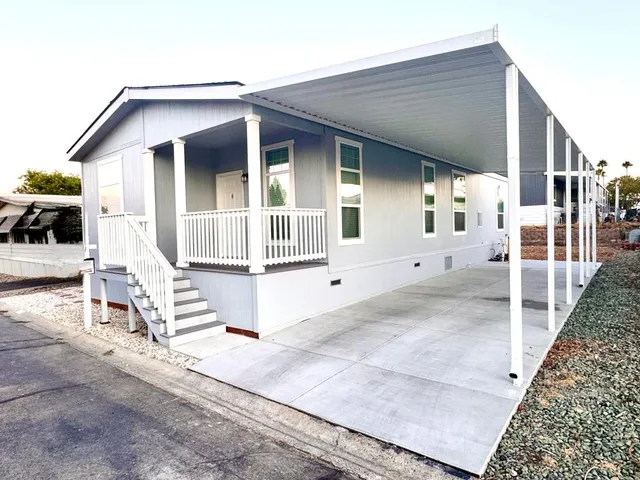 a view of house with wooden stairs and floor to ceiling window
