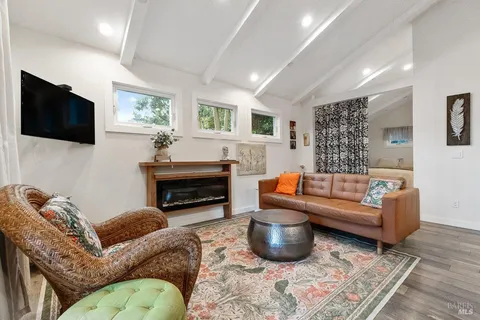 a living room with furniture a flat screen tv and kitchen view