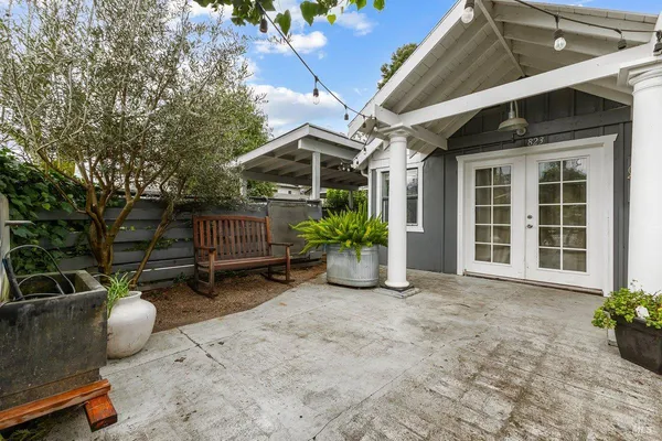 a view of a backyard with chairs and potted plants