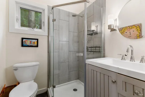 a bathroom with a sink a toilet and shower