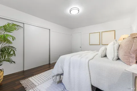 a bedroom with a bed and a potted plant