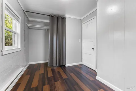 a view of a room with wooden floor and window