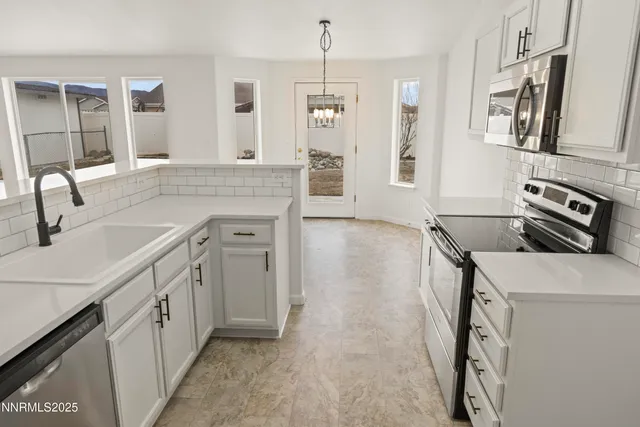 a kitchen that has a sink a stove and cabinets