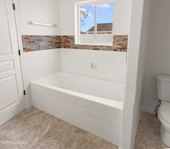 a white bath tub sitting next to a white toilet