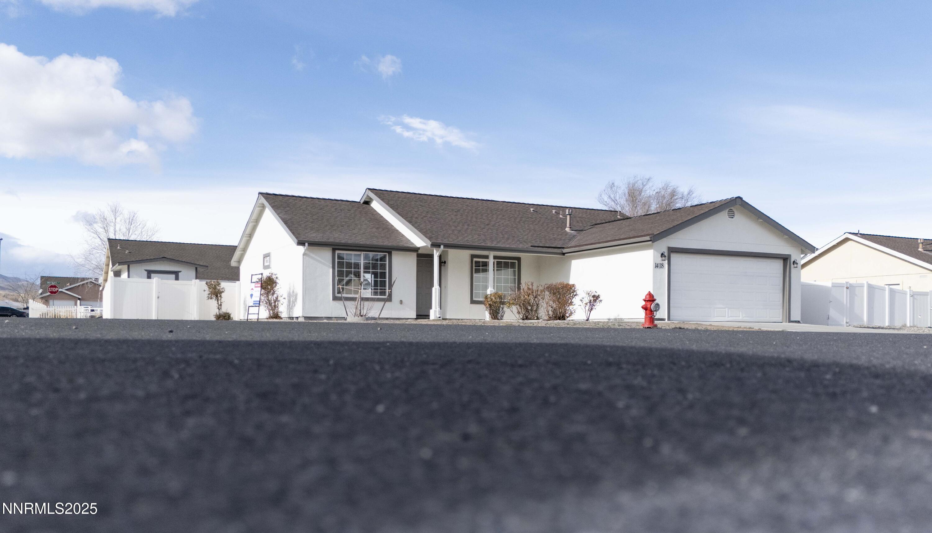 1418 Red Bluffs Way Fernley, NV 89408 - Photo 30 of 35 a front view of a house with a yard and garage