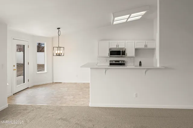 a kitchen with granite countertop a refrigerator a stove a microwave and a sink