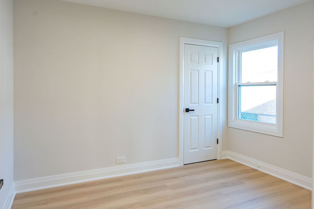 6964 West Cleveland Street Niles, IL 60714 - Photo 12 of 18 a view of an empty room with wooden floor and a window