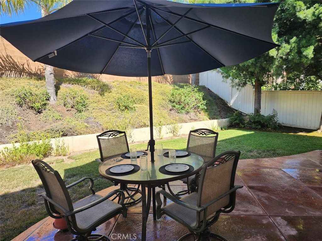 9 Calais Irvine, CA 92602 - Photo 16 of 21 a view of a patio with table and chairs under an umbrella