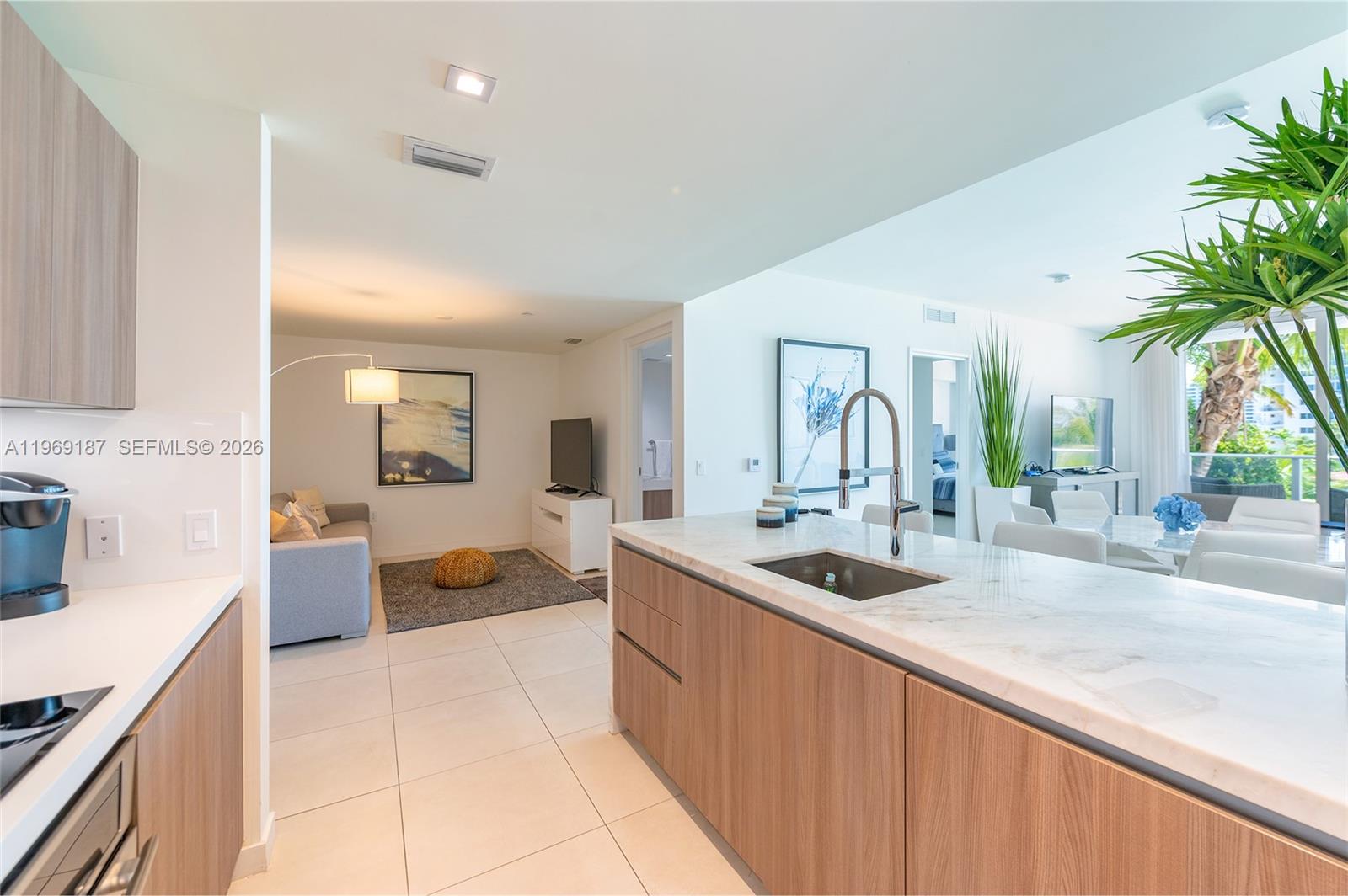 401 North Birch Road, Unit 502 Fort Lauderdale, FL 33304 - Photo 23 of 52 a large kitchen with a large counter top a sink a counter space and living room view