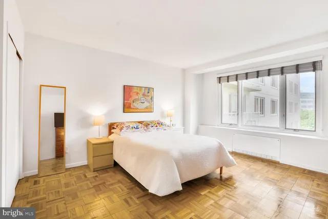 a bedroom with a bed and a large window