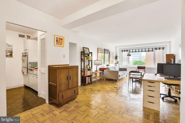 a view of a livingroom with workspace and a window