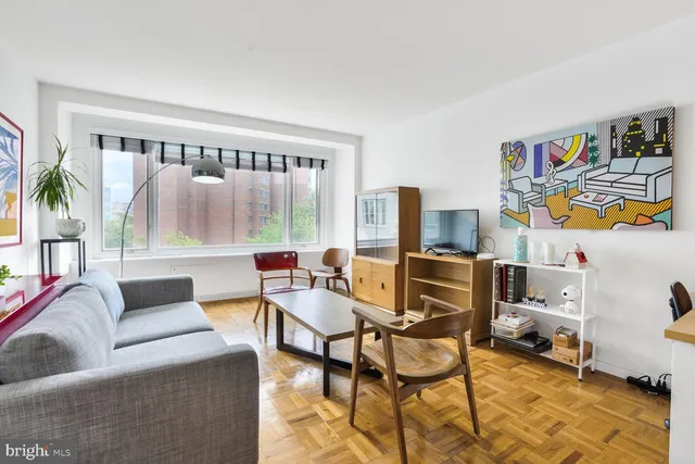 a living room with furniture and a floor to ceiling window