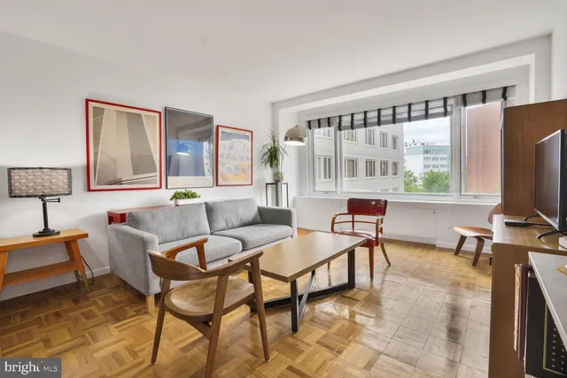 a living room with furniture a flat screen tv and a large window